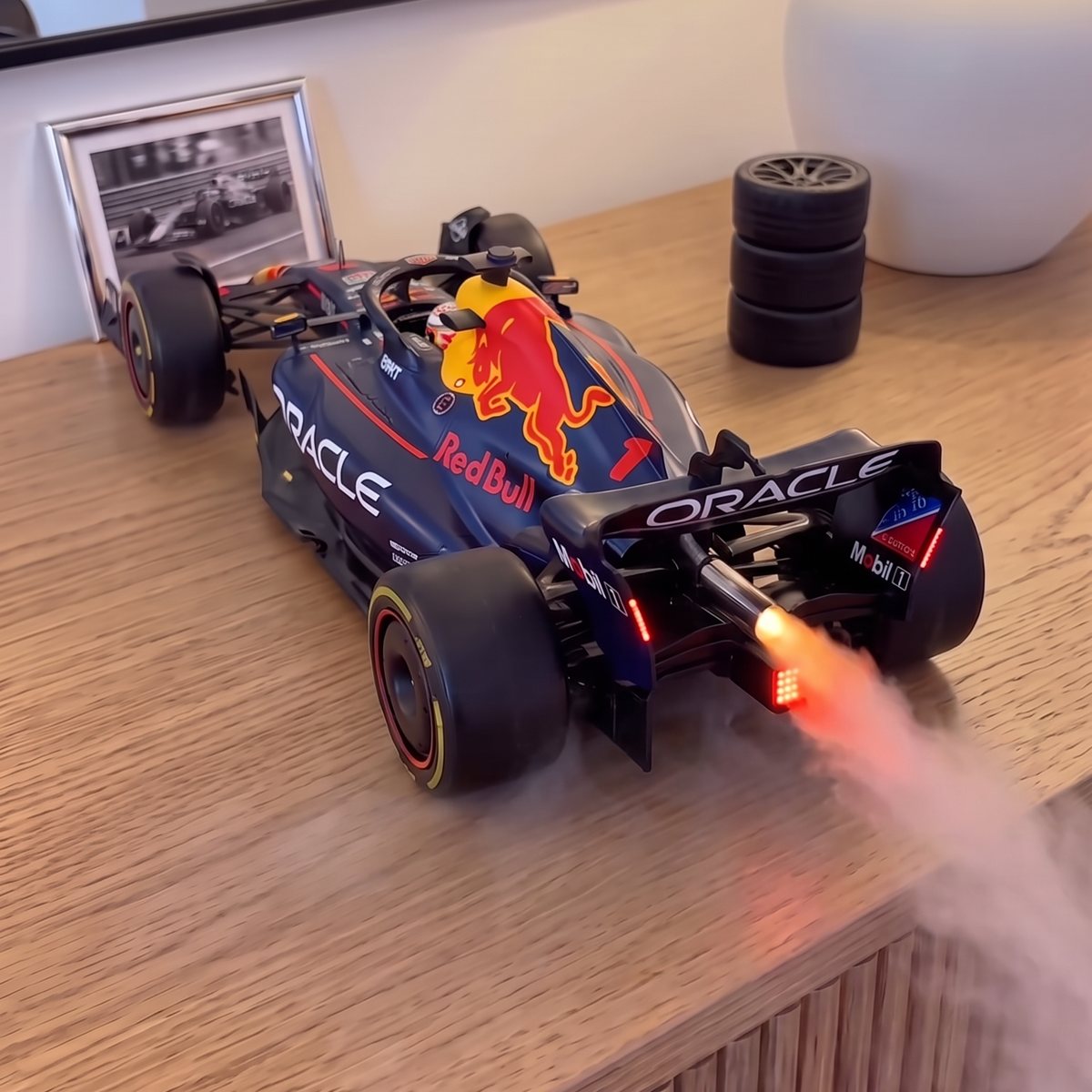 GRIDMIST F1 car mist diffuser in Red Bull navy, mist rolling from the glowing exhaust